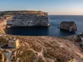 Malta pogoda w styczniu: słoneczny dzień nad zatoką z wieżą strażniczą i skalistymi klifami.