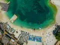 Albania, lipiec: słoneczna pogoda na plaży z turkusową wodą, leżakami i parasolami. Idealne warunki do wypoczynku.