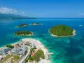 Rajska plaża z wysepkami, idealne albania atrakcje. Woda kusi turkusowym kolorem, a zielone wyspy zapraszają do odkrycia.