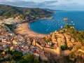 Widok na średniowieczne miasteczko z zamkiem i zatokę pełną łodzi. To idealne miejsce na odkrywanie atrakcji Costa Brava.
