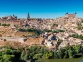 Widok na historyczne miasto Toledo w Hiszpanii, z katedrą i Alcázarem górującymi nad zabudowaniami.