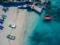 Idealne miejsce, gdzie na wakacje w styczniu: pusta plaża, łódki czekają na wodzie, a słońce grzeje.
