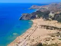 Malownicze plaże Rodos z turkusową wodą, piaszczystym wybrzeżem, leżakami i wodnym parkiem rozrywki.