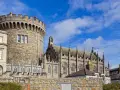Kamienna wieża i gotycka katedra w Dublinie, stolicy Irlandii, pod błękitnym niebem.