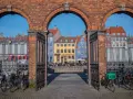 Kolorowe kamienice i kanał w Kopenhadze, idealne na zwiedzanie kopenhaga w jeden dzień. Rowerzyści czekają na przejazd.