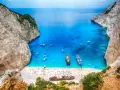 Zatoka Navagio, najcieplejsza wyspa grecka, z turkusową wodą, białym piaskiem, statkami i wrakiem.