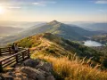 Bieszczady co warto zobaczyć: para na tarasie widokowym podziwia malowniczy szlak i jezioro w dolinie.