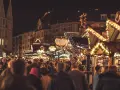 Tłoczny jarmark bożonarodzeniowy za granicą, pełen świateł i ludzi. Idealne miejsce, by poczuć magię świąt, gdy zastanawiasz się, gdzie na święta bożego narodzenia za granicę.