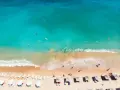 Słoneczna plaża w Bułgarii, turkusowe morze zaprasza do kąpieli. Leżaki i parasole czekają na plażowiczów.