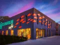 Oceanarium w Międzyzdrojach, jedna z głównych atrakcji, z neonowym napisem i pomarańczowymi rybkami na fasadzie.