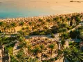 Rajska plaża z rzędami leżaków i palm. Idealne miejsce, by zastanowić się, gdzie do Egiptu na wakacje.