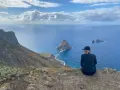 Widok na ocean z klifu, idealna teneryfa pogoda w grudniu. Kobieta w czapce podziwia skaliste wysepki.
