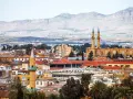 Widok na miasto z minaretami i budynkami o czerwonych dachach, w tle góry. To stolica Cypru, Nikozja.