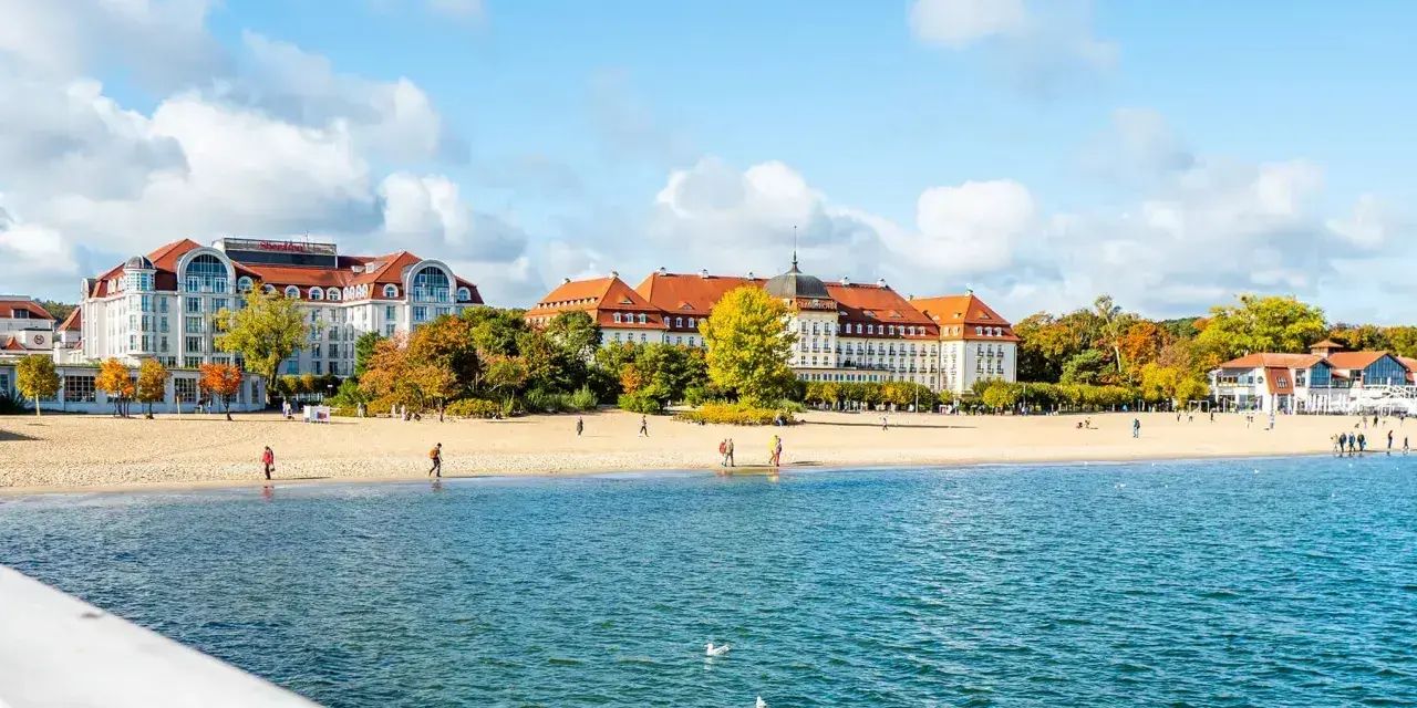 Piękna plaża i zabytkowe budynki nad morzem. Idealne miejsce, gdzie na wakacje w październiku, gdy jesienne liście mienią się kolorami.