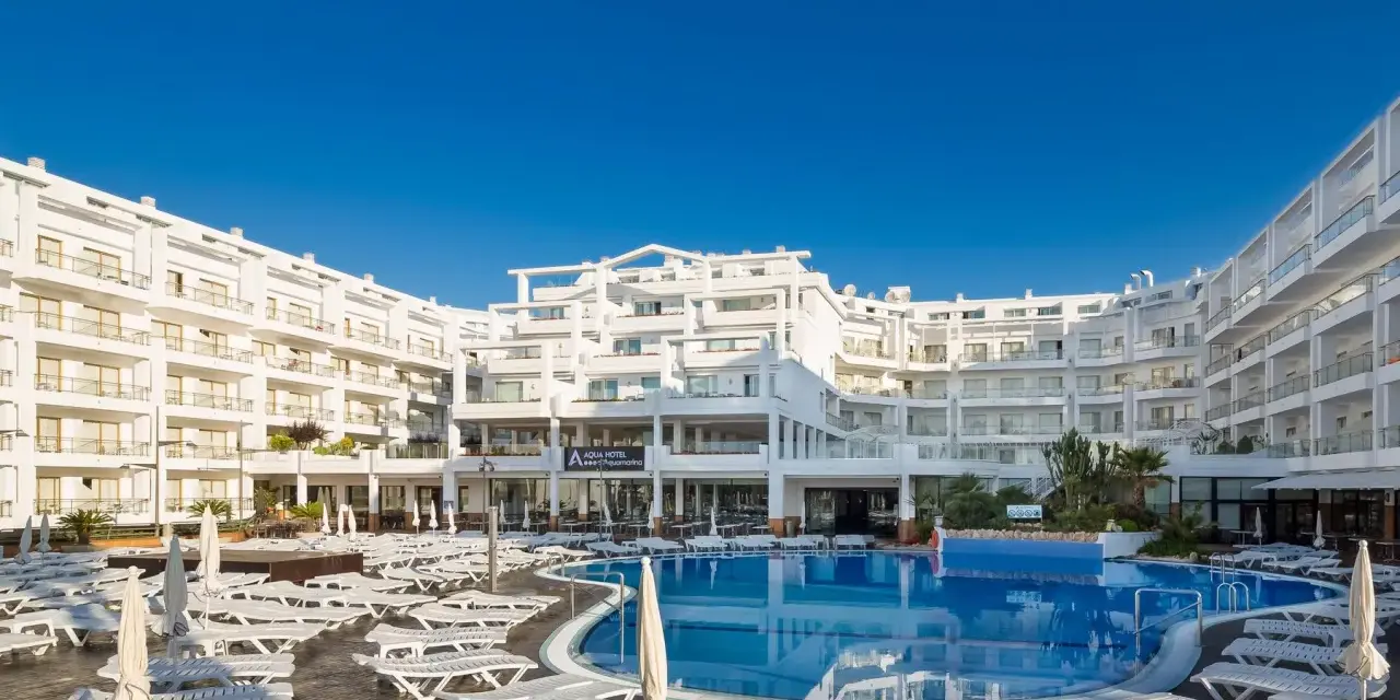 Idealna pogoda na Costa Brava: hotel z basenem i leżakami pod błękitnym niebem.