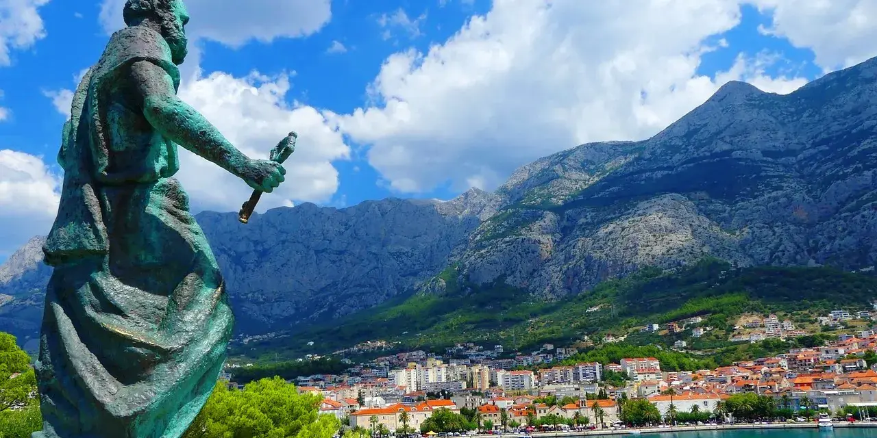 Pomnik na tle gór i miasta. Makarska atrakcje zachwycają widokiem na błękitne morze i skaliste szczyty.