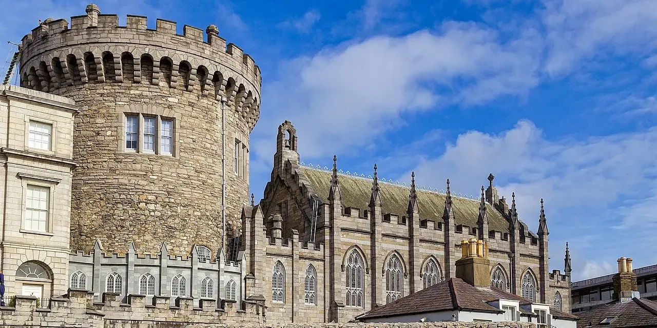 Kamienna wieża i gotycka katedra w Dublinie, stolicy Irlandii, pod błękitnym niebem.