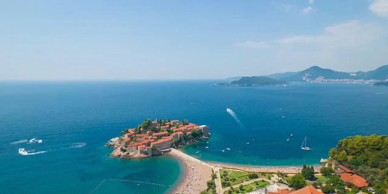 Wyspa Sveti Stefan, perła Czarnogóry, gdzie jechać na niezapomniane wakacje. Urokliwa plaża, turkusowe morze i malownicze widoki.