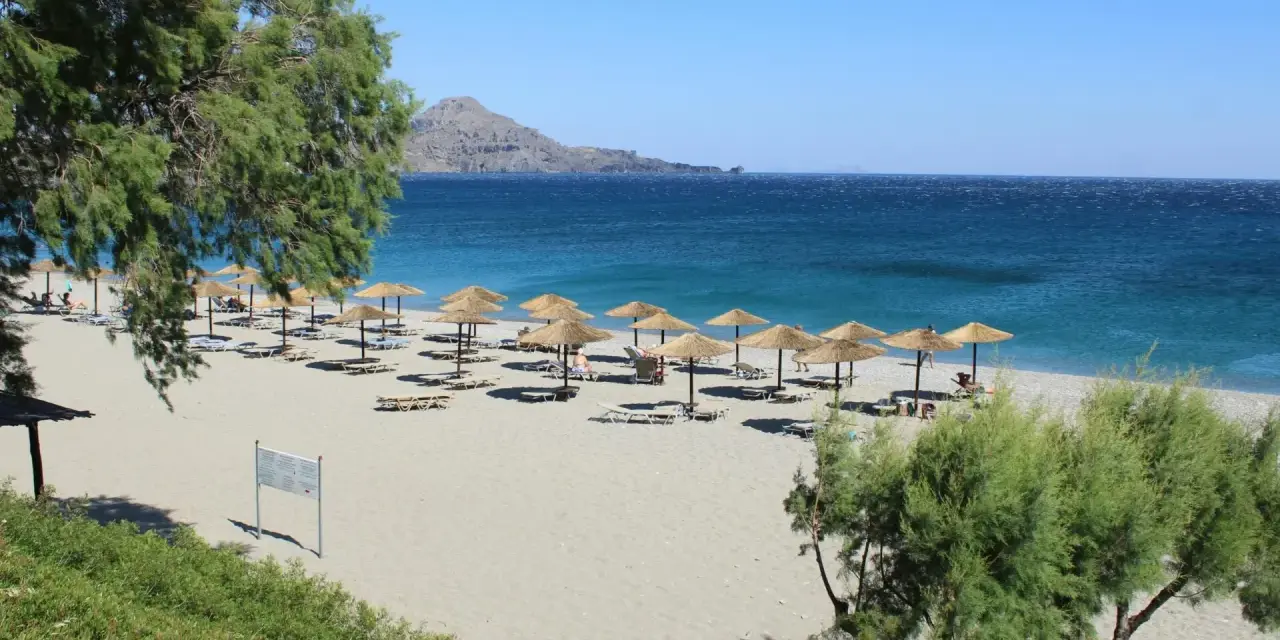 Piękna plaża z parasolami i leżakami, idealne miejsce na wakacje w Grecji.