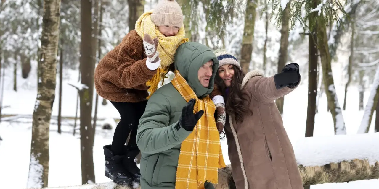 Rodzina robi sobie selfie w zimowym lesie. Idealne miejsce, gdzie na ferie z nastolatkiem, pełne śniegu i radości.