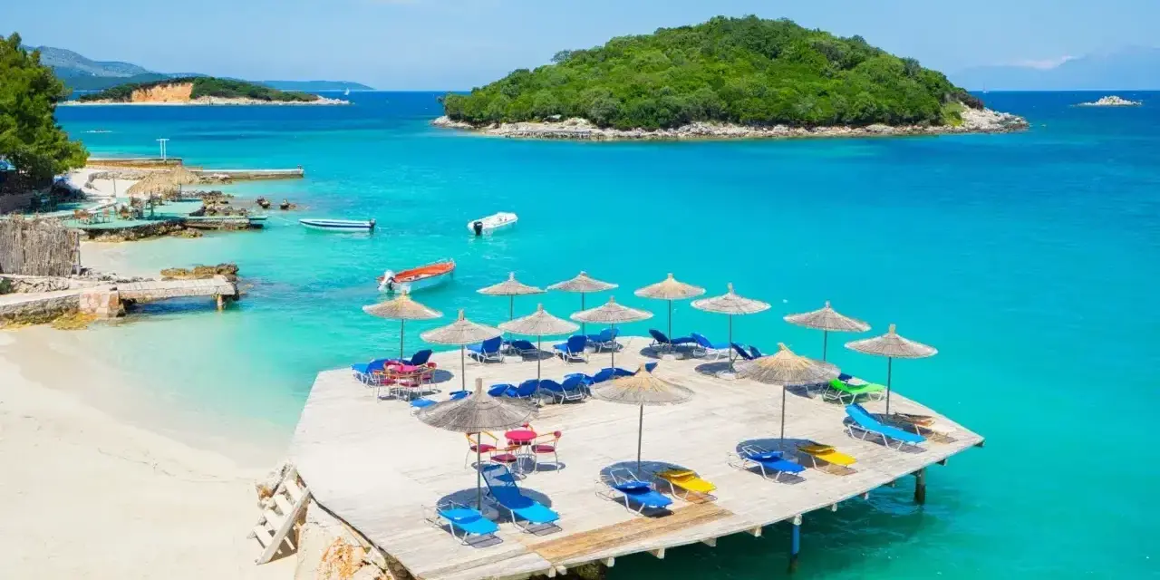 Rajskie albania plaże z turkusową wodą, leżakami i parasolami. Idealne miejsce na wakacje.