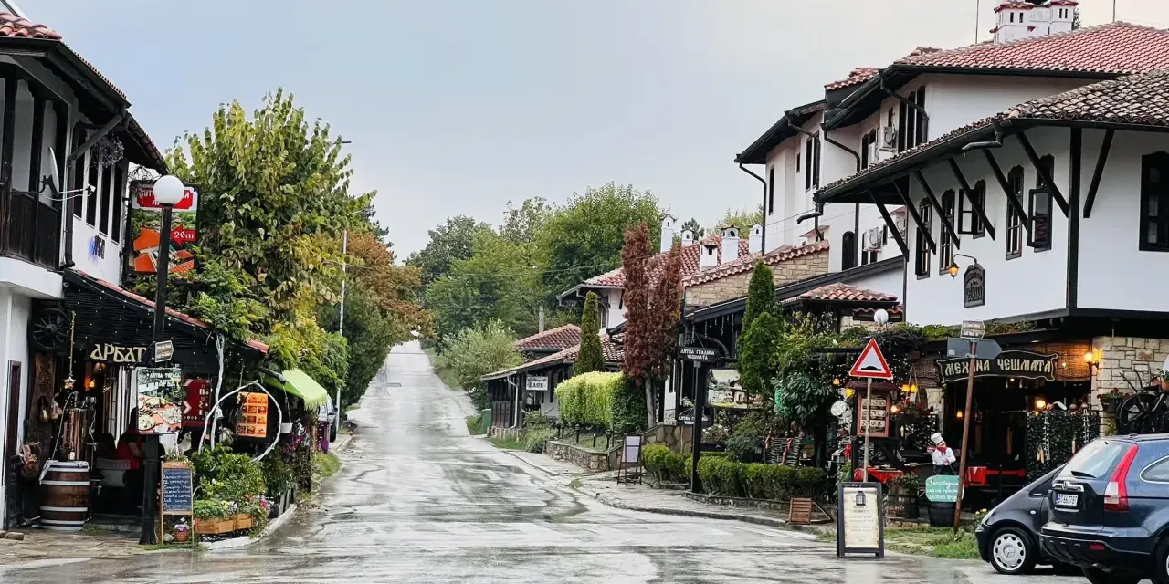 Ulica w Wielkim Tyrnowie po deszczu, z tradycyjną architekturą i sklepikami.