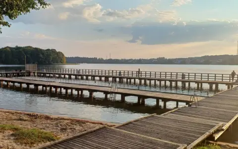 Drewniane mola nad jeziorem, idealne na spacer i podziwianie zachodu słońca. Mrągowo atrakcje dla każdego.
