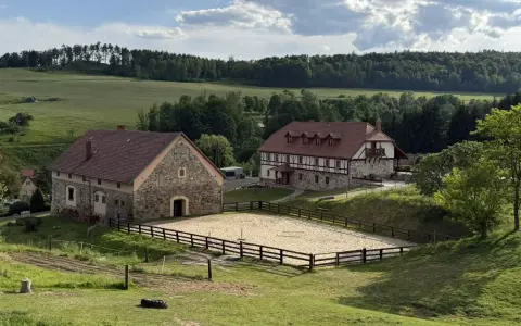 Malowniczy krajobraz z budynkami i ujeżdżalnią koni. Idealne miejsce na agroturystykę Dolny Śląsk.
