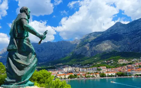 Pomnik na tle gór i miasta. Makarska atrakcje zachwycają widokiem na błękitne morze i skaliste szczyty.