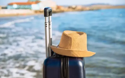 Walizka i kapelusz na plaży. Idealna pogoda w Bułgarii w październiku na ostatnie chwile lata.