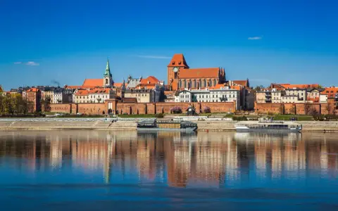 Widok na zabytkowe centrum Torunia z Wisłą w tle. Zobacz, co warto zobaczyć w Toruniu: katedrę, ratusz i średniowieczne mury.
