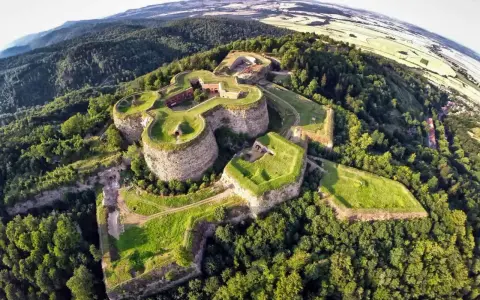 Niedzielna wycieczka na Dolny Śląsk to widok na imponującą twierdzę na wzgórzu, otoczoną zielonymi lasami i polami.
