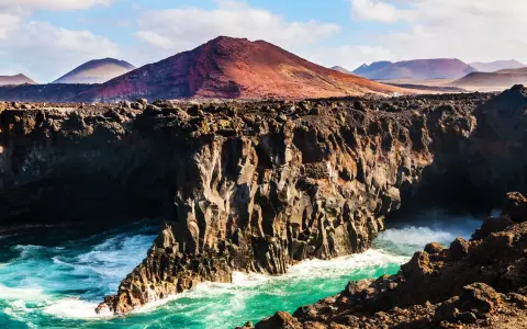 Wulkaniczne klify na Lanzarote, turkusowe morze i malownicze góry. Idealna pogoda na odkrywanie wyspy.