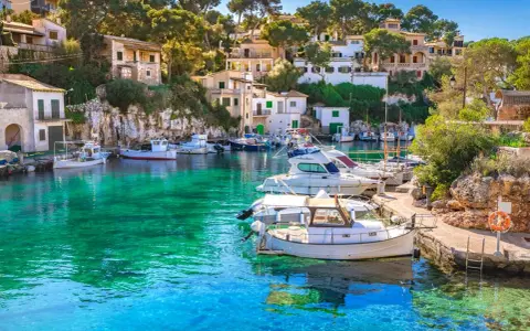 Malowniczy port na Balearach, gdzie turkusowa woda otacza zacumowane łodzie. Takie widoki oferują baleary, jakie wyspy zachwycają każdego!