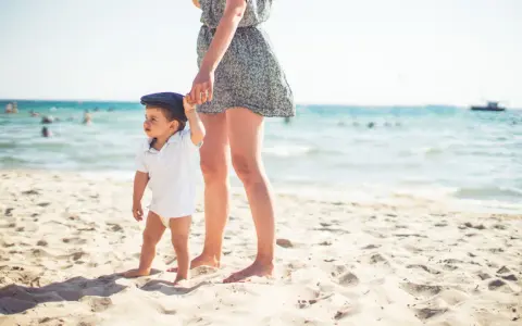Mama i dziecko na plaży, idealne miejsce, by zapytać, gdzie lecieć w kwietniu. Słońce, piasek i morze.