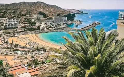 Gran Canaria pogoda idealna na plażowanie. Turkusowa woda, złoty piasek i palmy tworzą rajski widok.