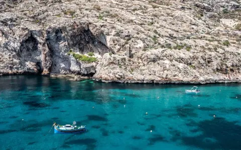 Malta, grudzień: turkusowa woda, skaliste klify i łodzie. Pogoda idealna na rejs.