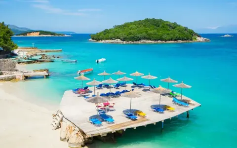 Rajskie albania plaże z turkusową wodą, leżakami i parasolami. Idealne miejsce na wakacje.