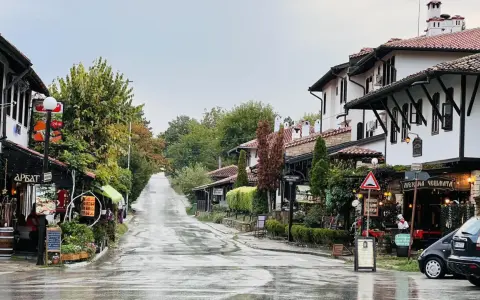 Ulica w Wielkim Tyrnowie po deszczu, z tradycyjną architekturą i sklepikami.