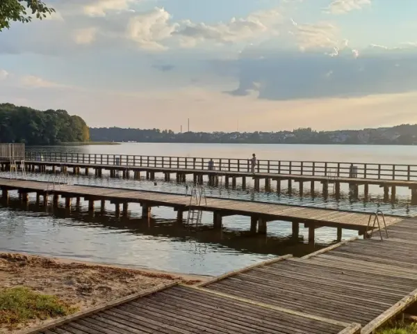 Drewniane mola nad jeziorem, idealne na spacer i podziwianie zachodu słońca. Mrągowo atrakcje dla każdego.
