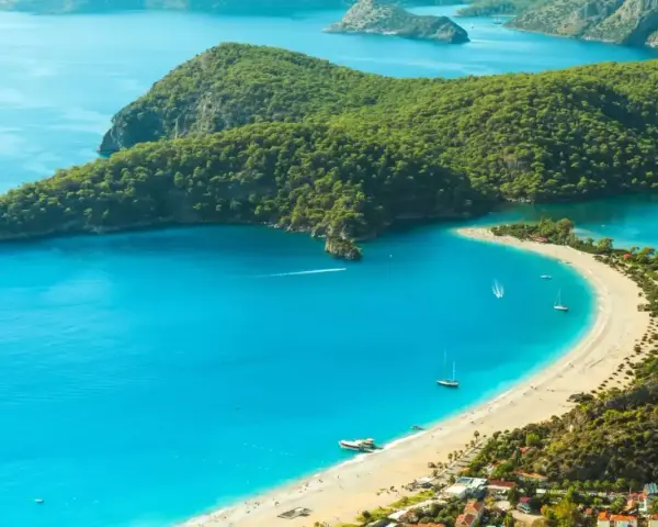 Idealne wakacje w listopadzie: turkusowa woda, piaszczysta plaża i zielone wzgórza.