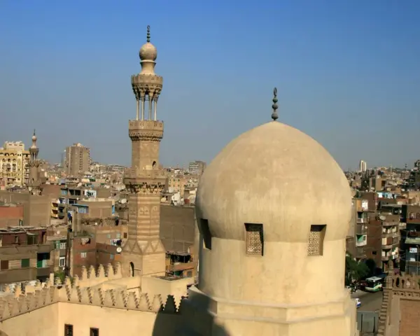 Widok na kopułę i minaret meczetu w Kairze, stolicy Egiptu, na tle miejskiego krajobrazu.