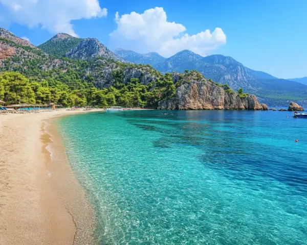 Piękna plaża w Turcji z turkusową wodą, górami i sosnami. Idealne miejsce na relaks.