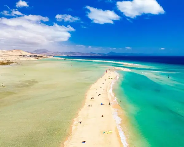 Plaża na Fuerteventurze, z turkusową wodą i piaszczystym cyplem, zachęca do wypoczynku. Czy to Fuerteventura czy Teneryfa, widok zapiera dech.