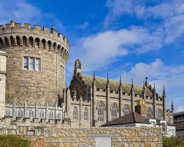 Kamienna wieża i gotycka katedra w Dublinie, stolicy Irlandii, pod błękitnym niebem.