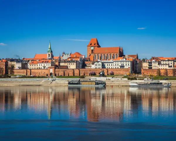 Widok na zabytkowe centrum Torunia z Wisłą w tle. Zobacz, co warto zobaczyć w Toruniu: katedrę, ratusz i średniowieczne mury.