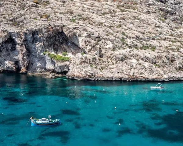 Malta, grudzień: turkusowa woda, skaliste klify i łodzie. Pogoda idealna na rejs.