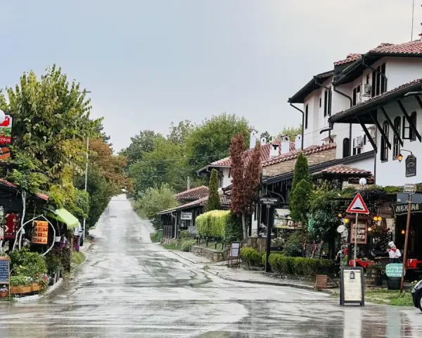 Ulica w Wielkim Tyrnowie po deszczu, z tradycyjną architekturą i sklepikami.