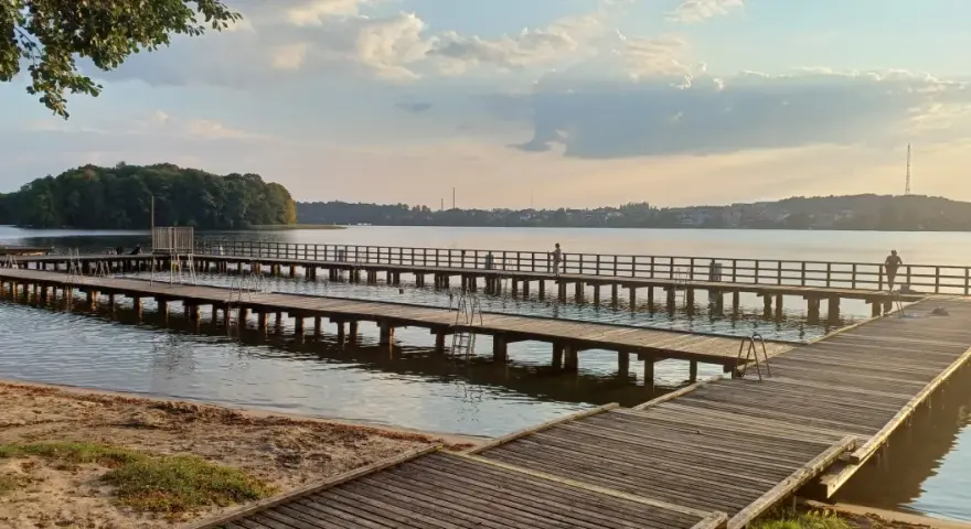 Drewniane mola nad jeziorem, idealne na spacer i podziwianie zachodu słońca. Mrągowo atrakcje dla każdego.