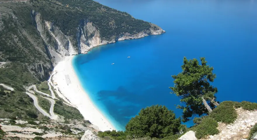 Malownicza plaża Myrtos na Kefalonii, Grecja w październiku. Kręta droga prowadzi do białego piasku i turkusowego morza.